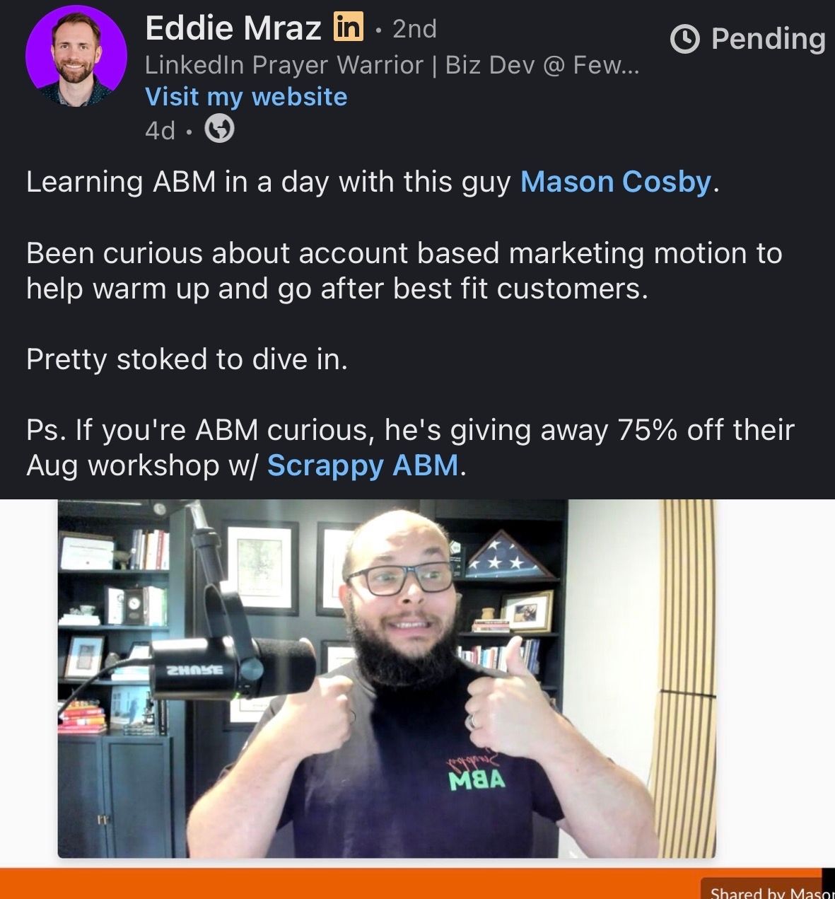 A bearded man in glasses gives two thumbs up in front of a microphone, wearing a black Mastering MBA shirt. Text above describes interest in ABM and a workshop with Mason Cosby and Scrappy ABM.